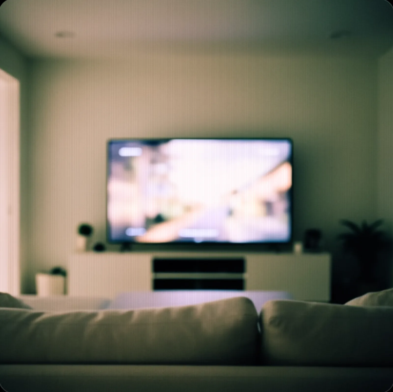 An empty living room with a television playing